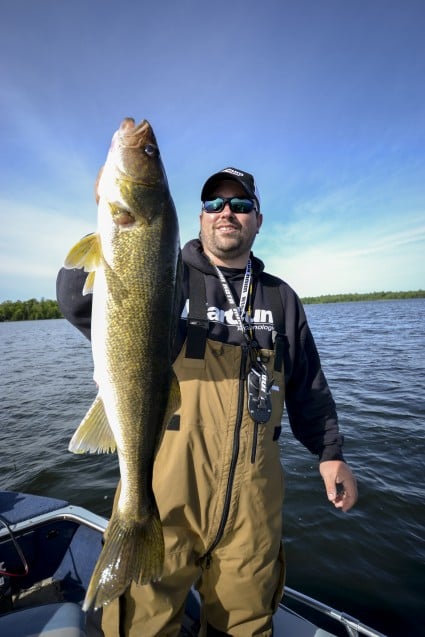 Joel Nelson hoisting a Leech Lake Walleye, caught on a hammered gold spinner